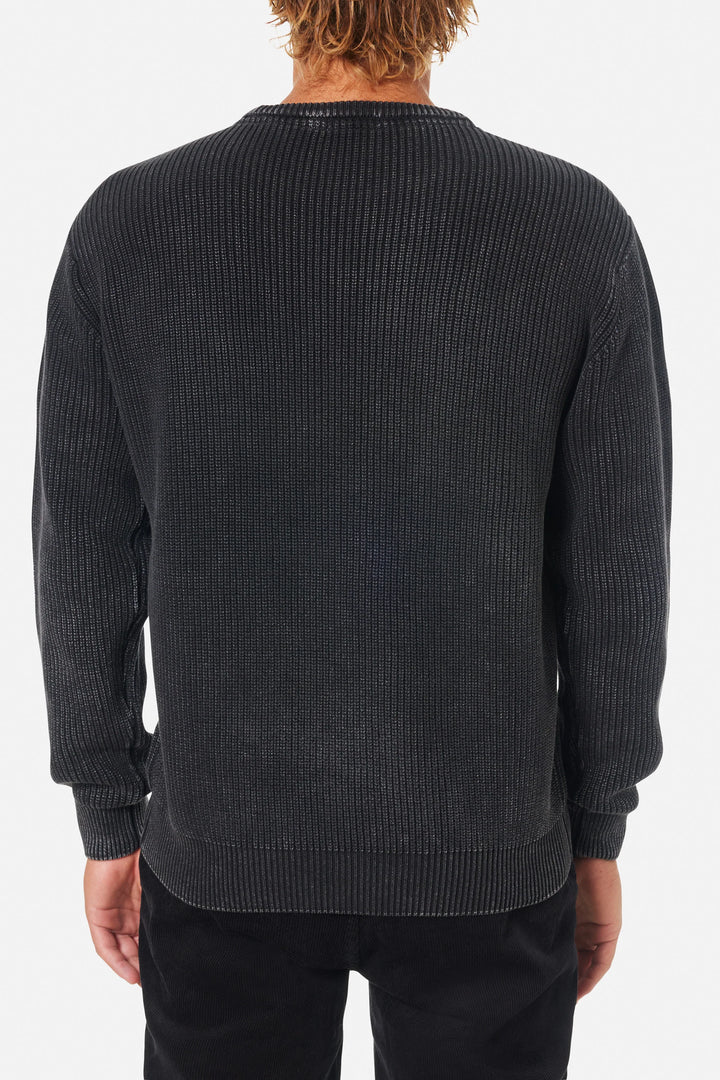 Person wearing a dark gray ribbed sweater on a white background