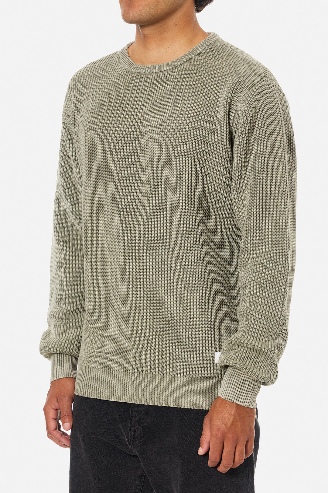 Person wearing a textured green sweater on a white background