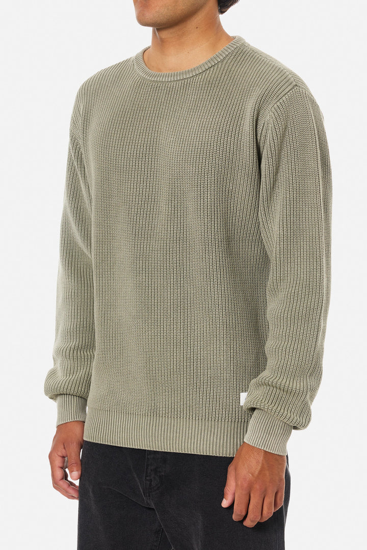Person wearing a textured green sweater on a white background