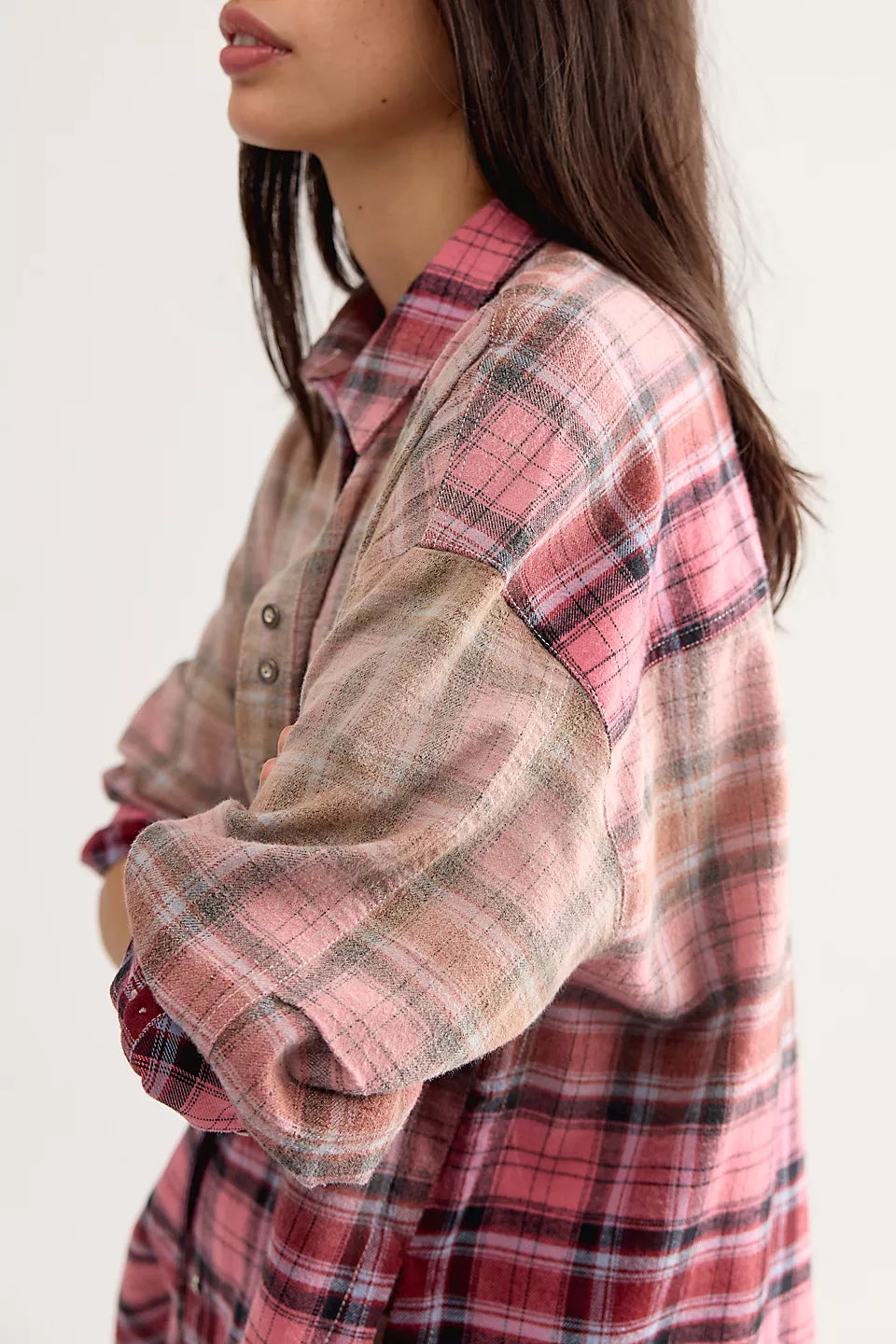 Side view of woman wearing pink plaid shirt