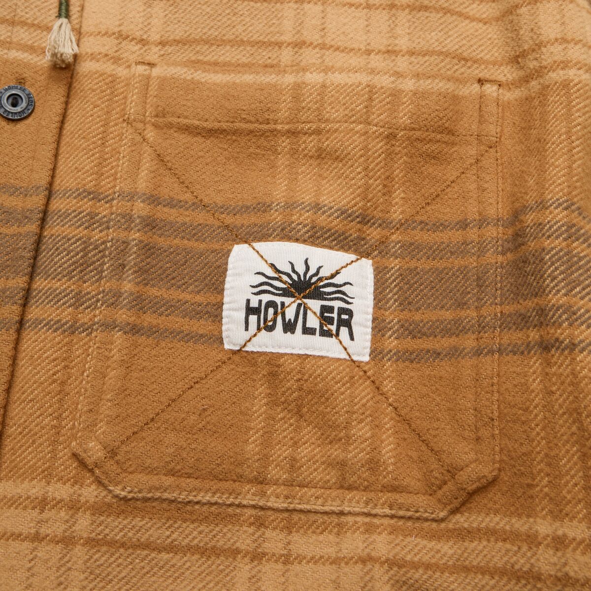Close-up of a plaid fabric with a Howler brand label.