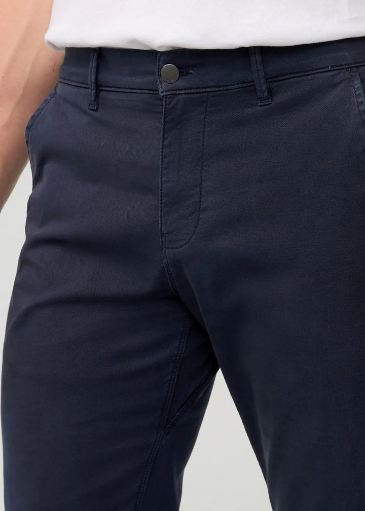 Navy pants with a white shirt on a light gray background