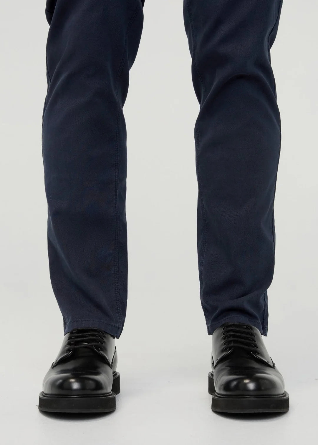 Navy blue pants and black shoes on a white background