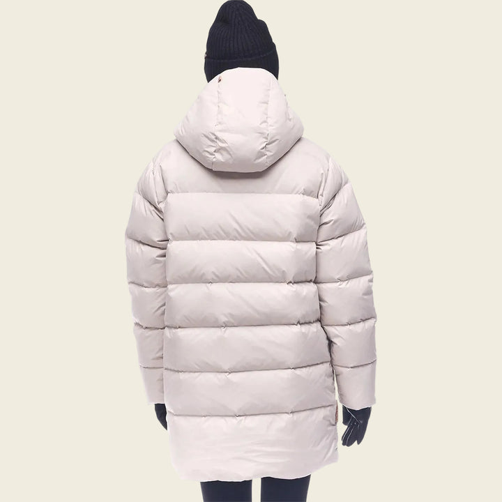 Person wearing a light pink puffer coat on a white background