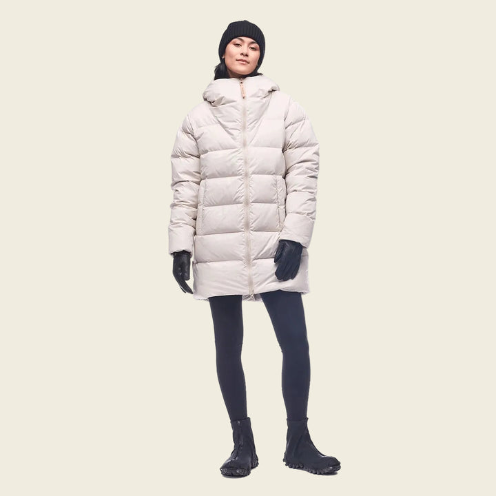 Person wearing a long white puffer coat on a white background