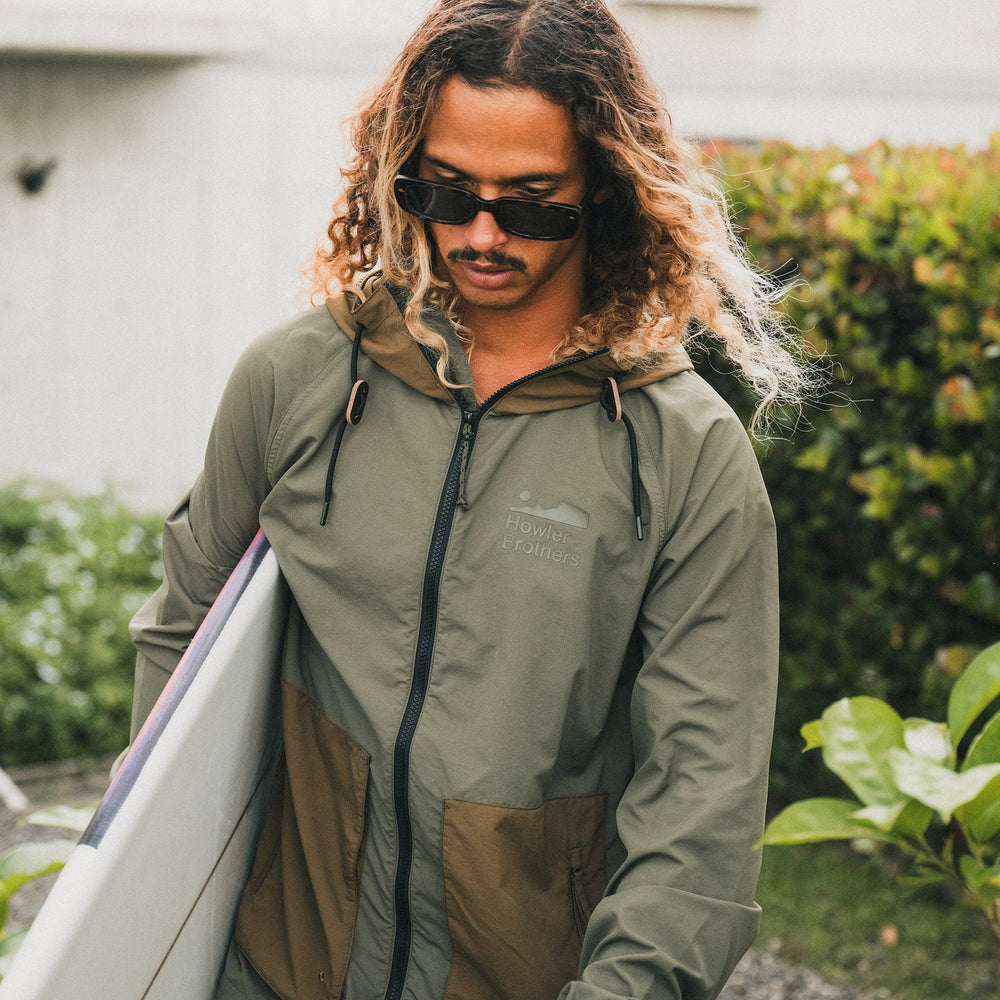 Howler Bros Seabreacher Jacket | Oregano Teak Model with surfboard