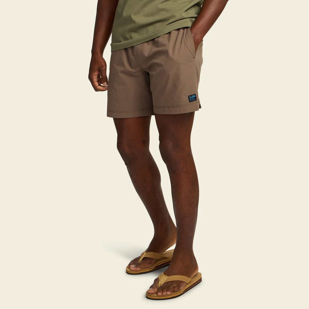 Person wearing beige shorts on a beige background