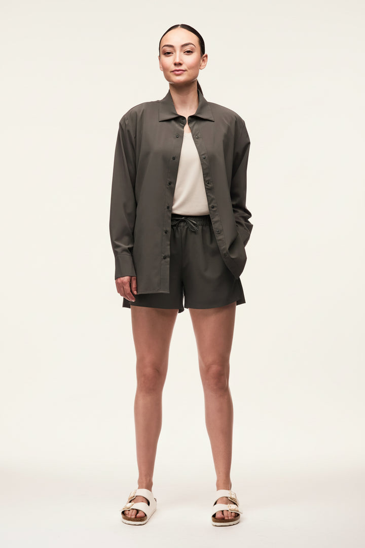 Woman wearing a green jacket and shorts on a white background