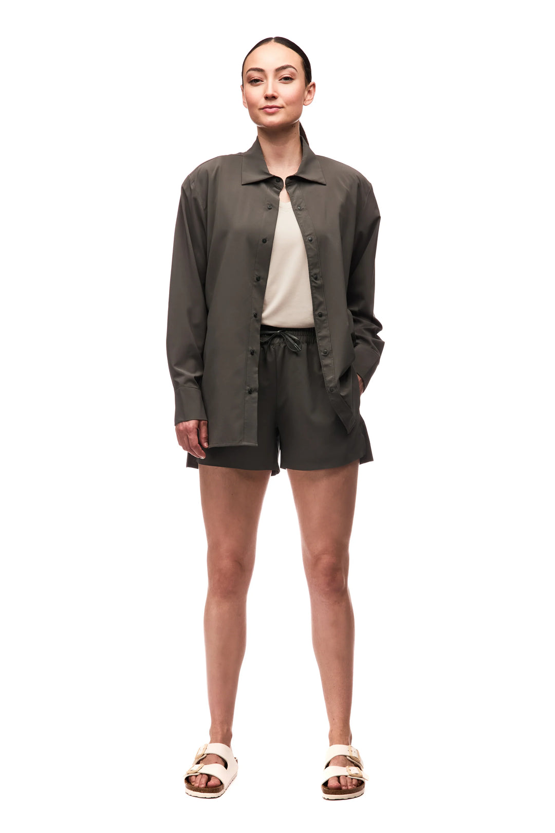 Woman wearing a green jacket and shorts on a white background