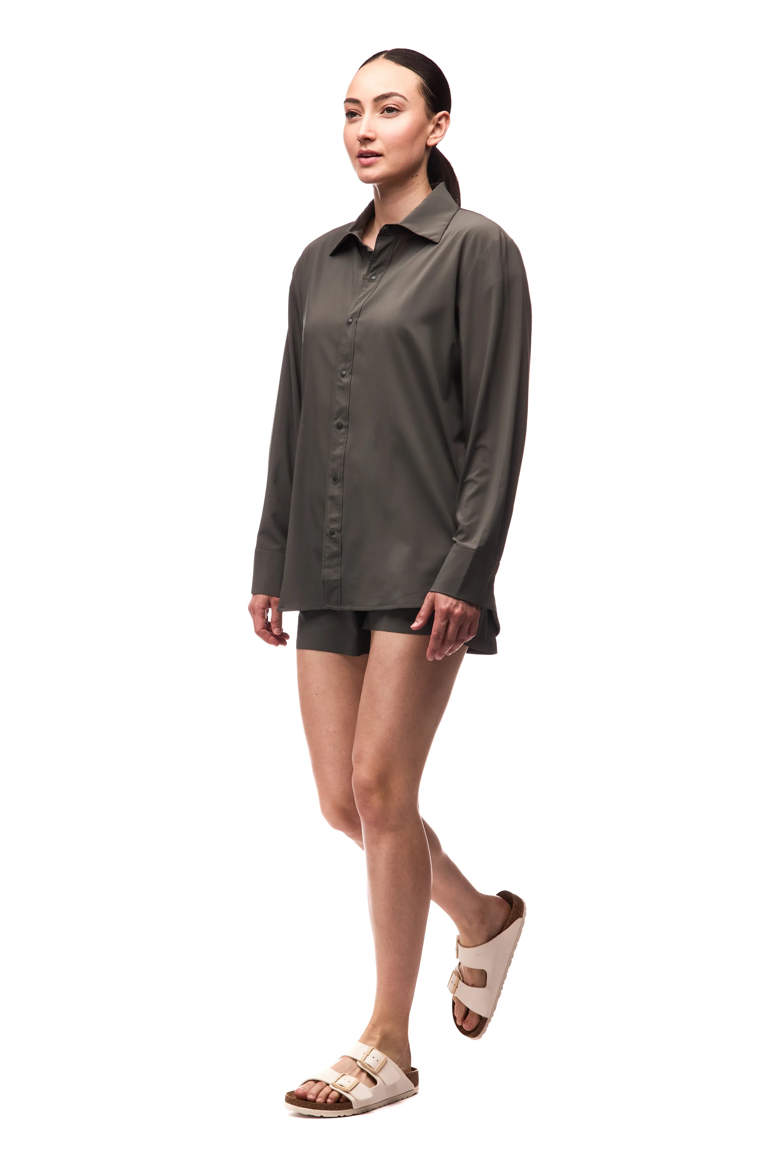 Woman wearing a green jacket and shorts on a white background