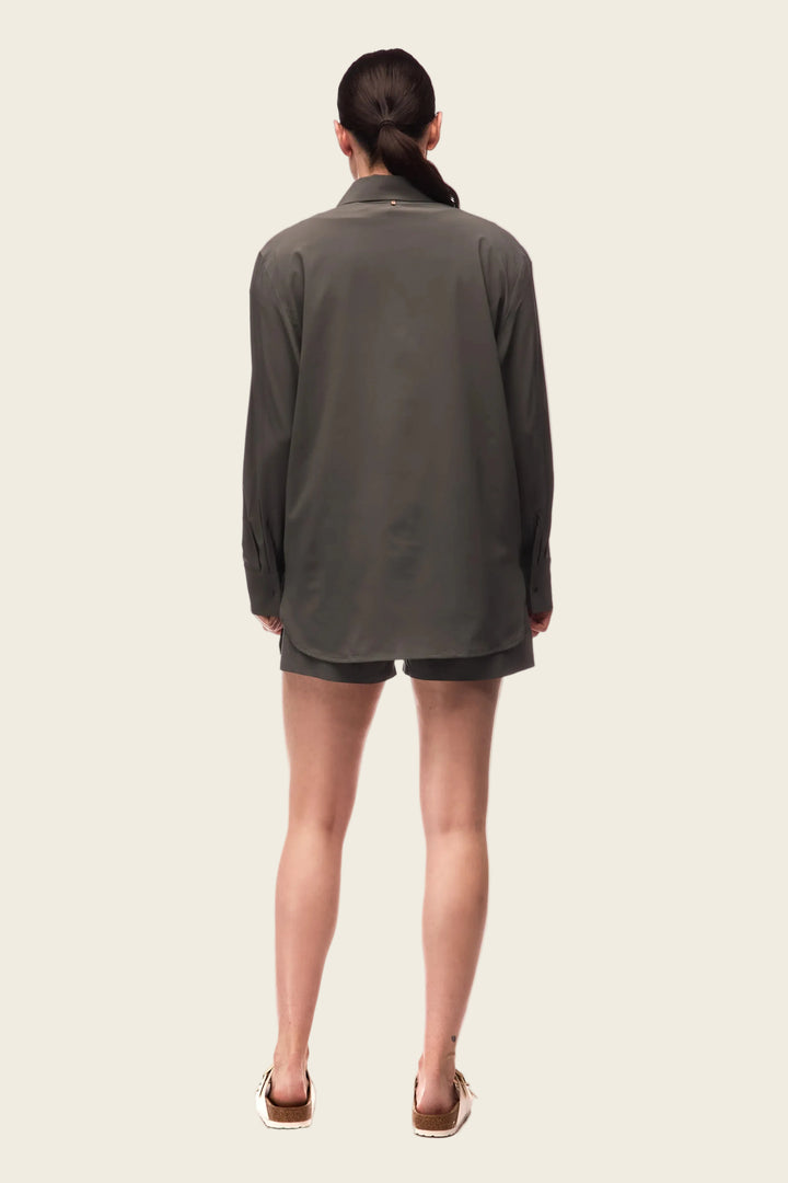 Person wearing a gray long-sleeve shirt and shorts on a white background