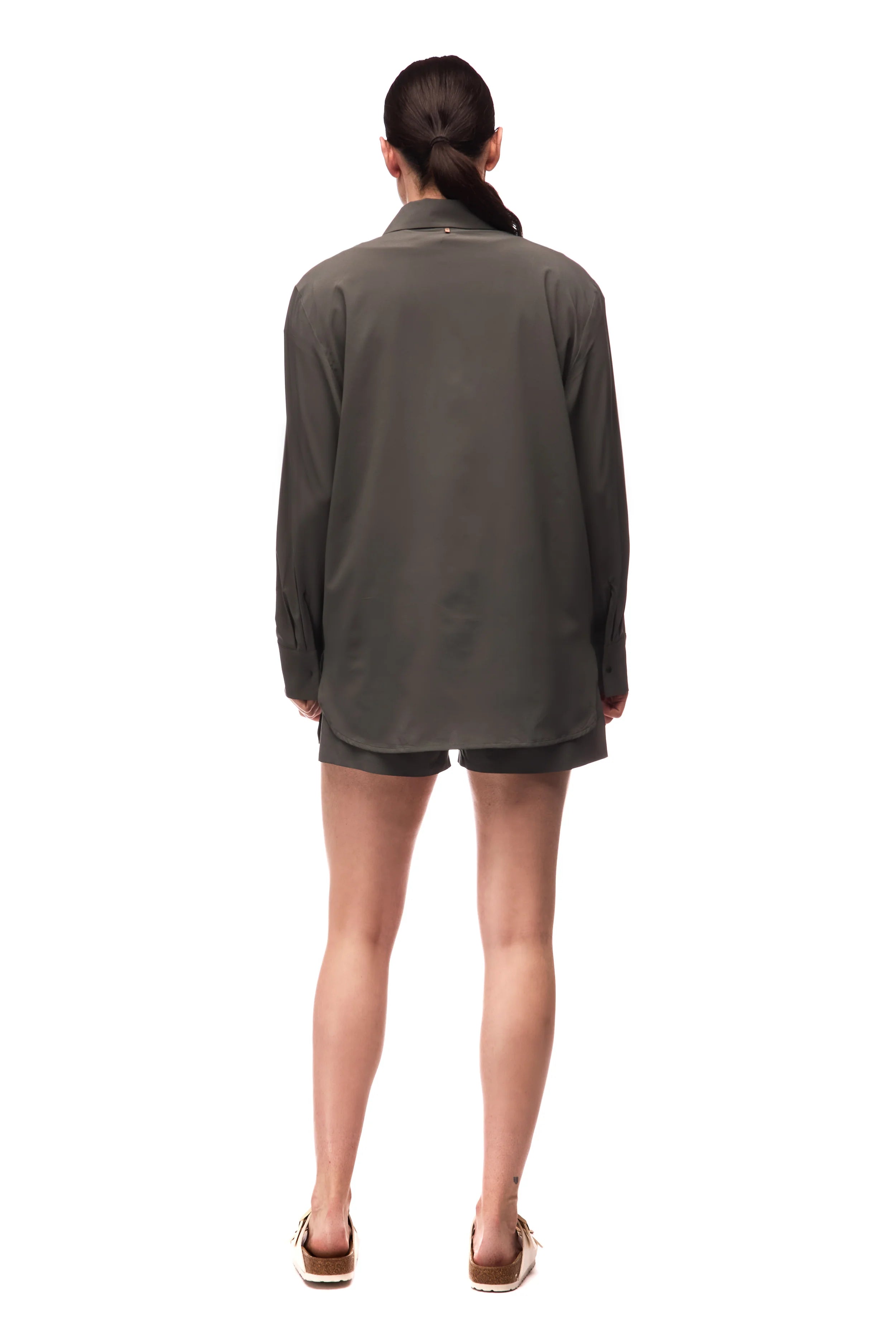 Woman wearing a green jacket and shorts on a white background