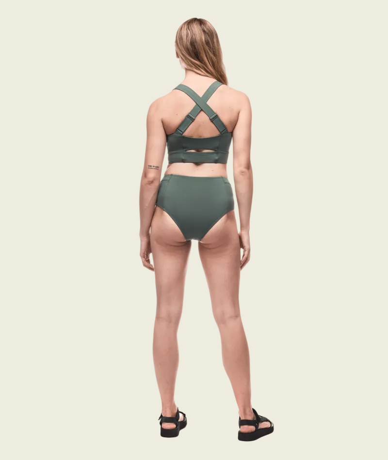 Woman wearing a green bikini set on a white background