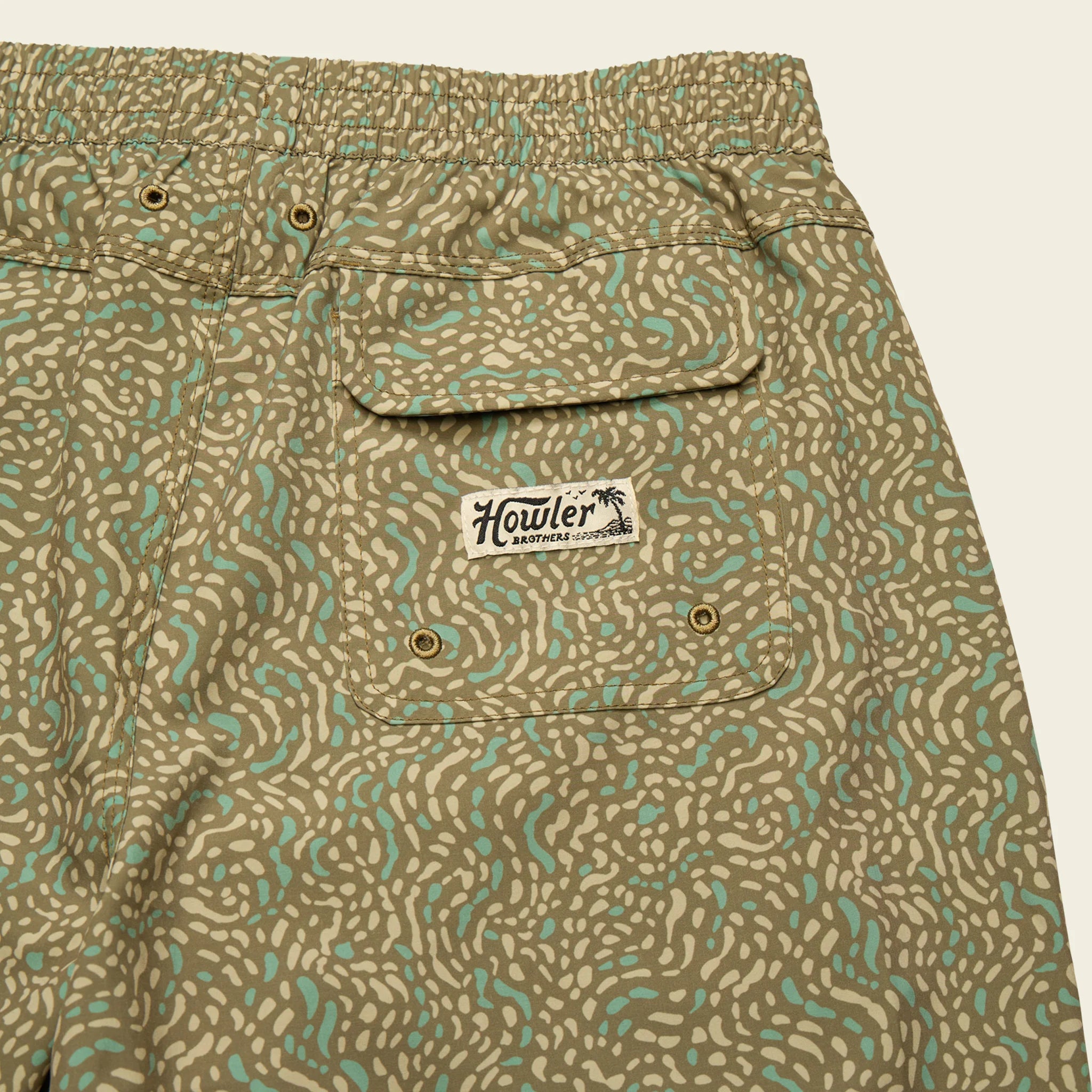 Patterned shorts with a visible brand label on a beige background