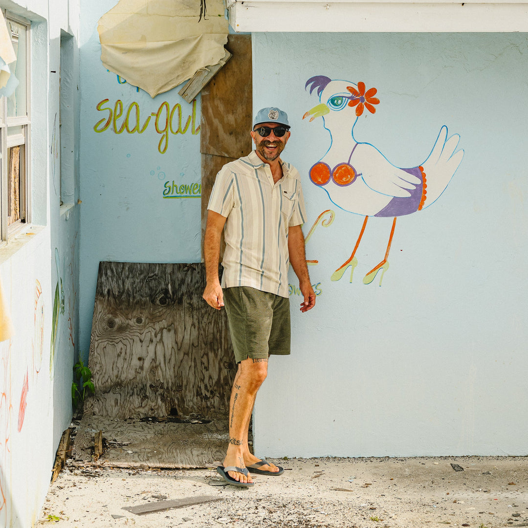 Man standing in front of a wall with a colorful seagull mural and 'Seagal' text.