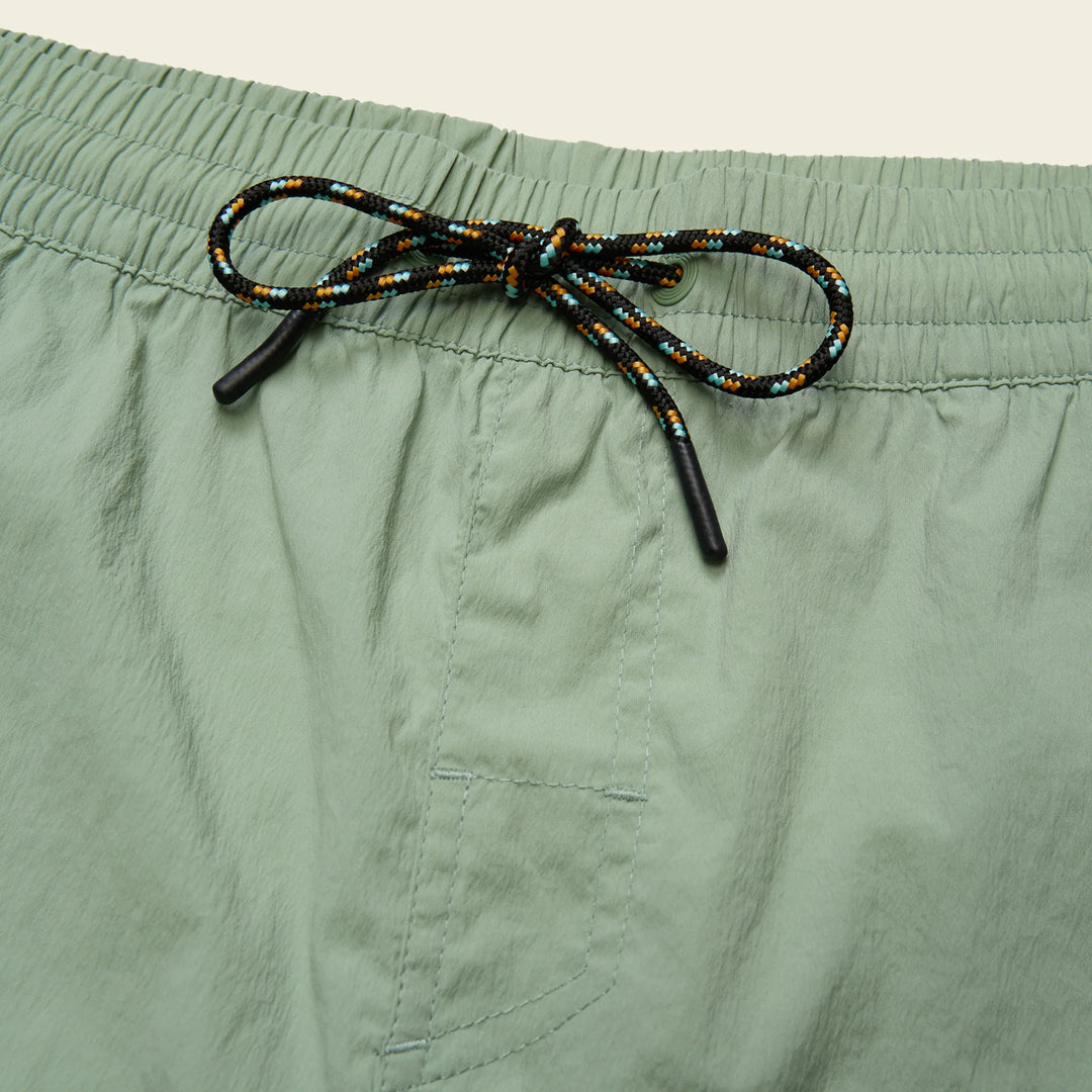 Green shorts with a beaded drawstring on a beige background