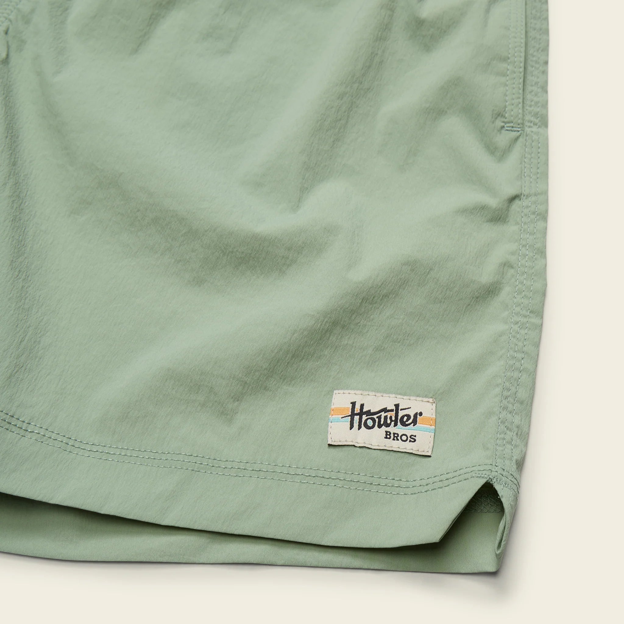 Close-up of a green shorts with a brand label on a white background
