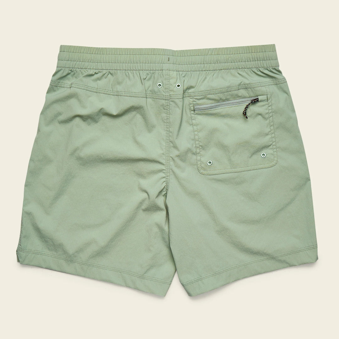 Green shorts with a pocket and zipper on a beige background