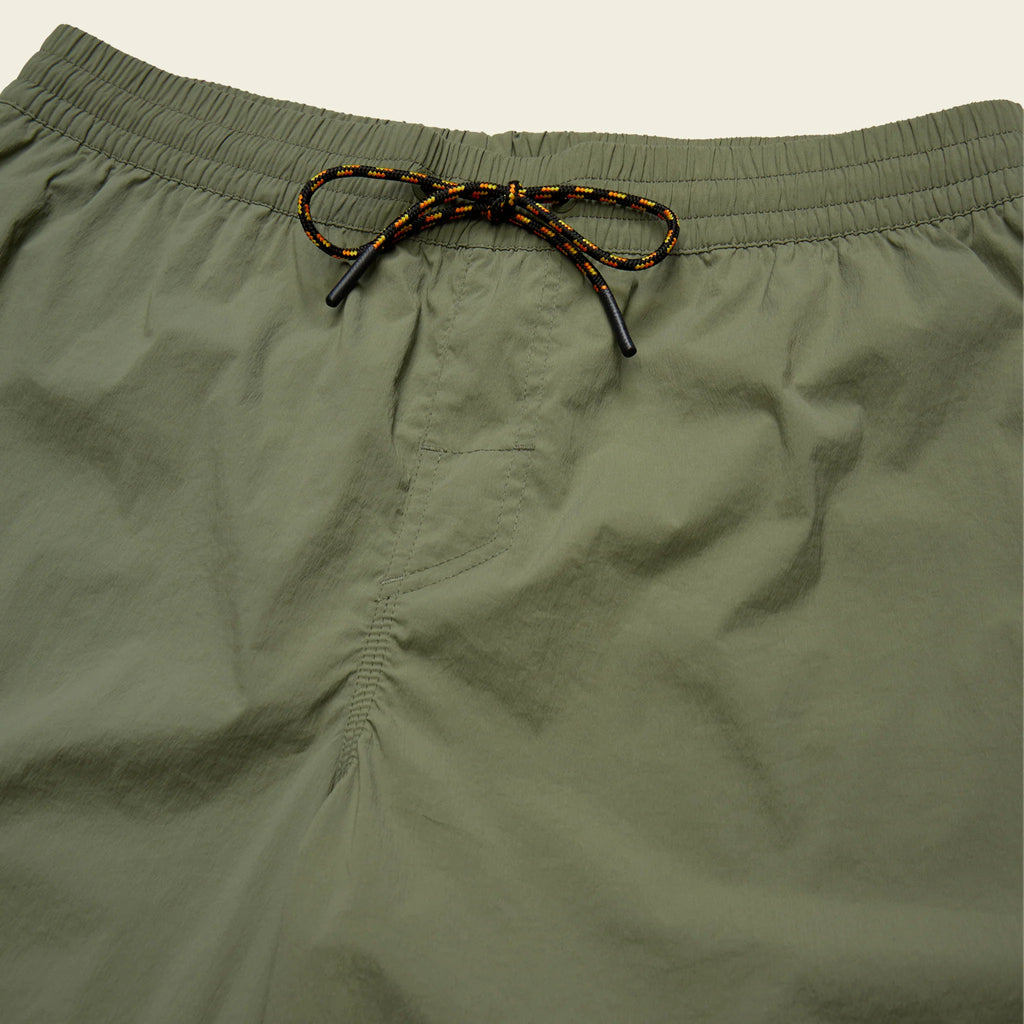 Close-up of olive green shorts with a drawstring on a light gray background