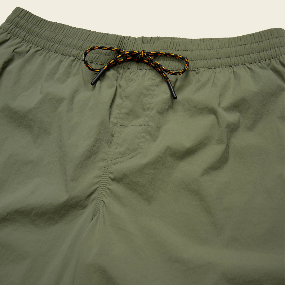 Close-up of olive green shorts with a drawstring on a light gray background