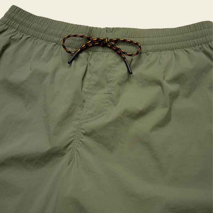 Close-up of olive green shorts with a drawstring on a light gray background