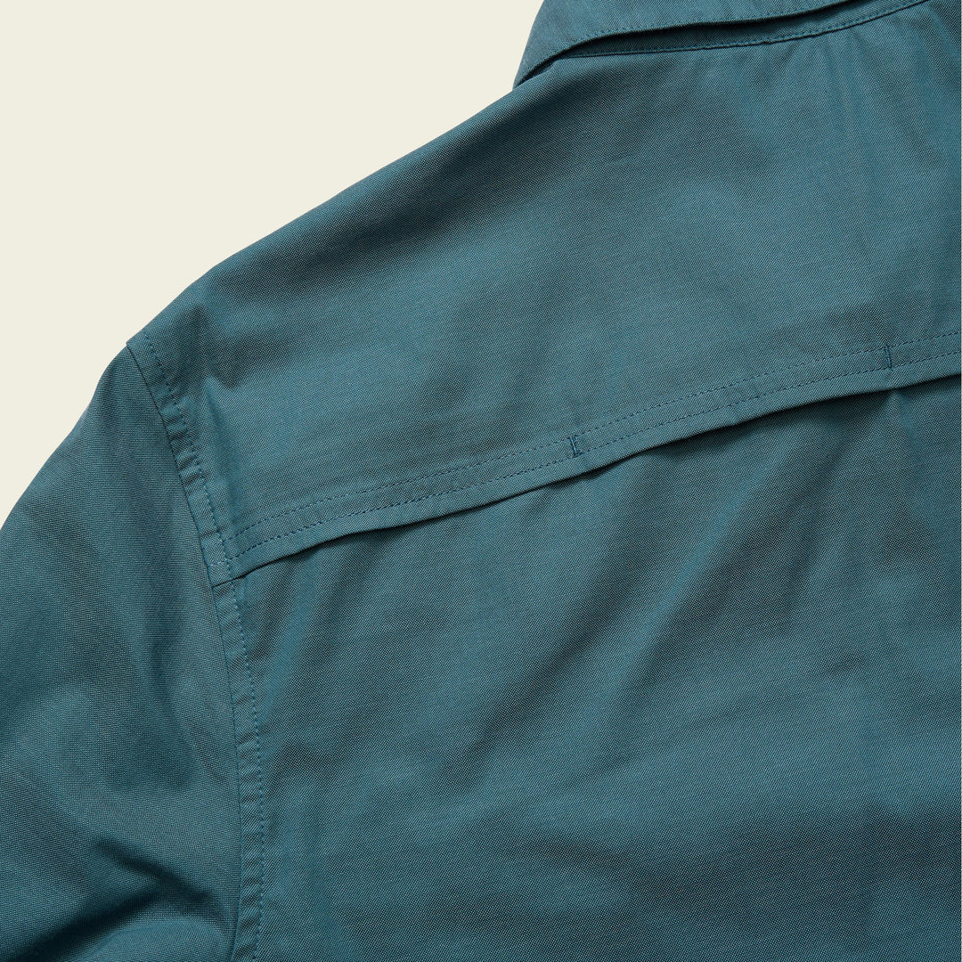 Close-up of a teal shirt collar on a beige background