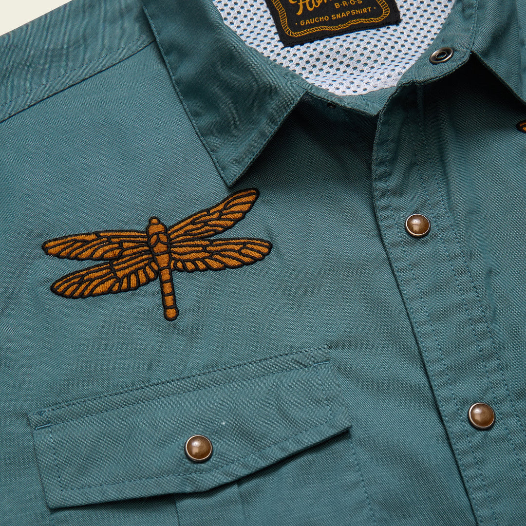 Green jacket with an embroidered dragonfly design on a white background