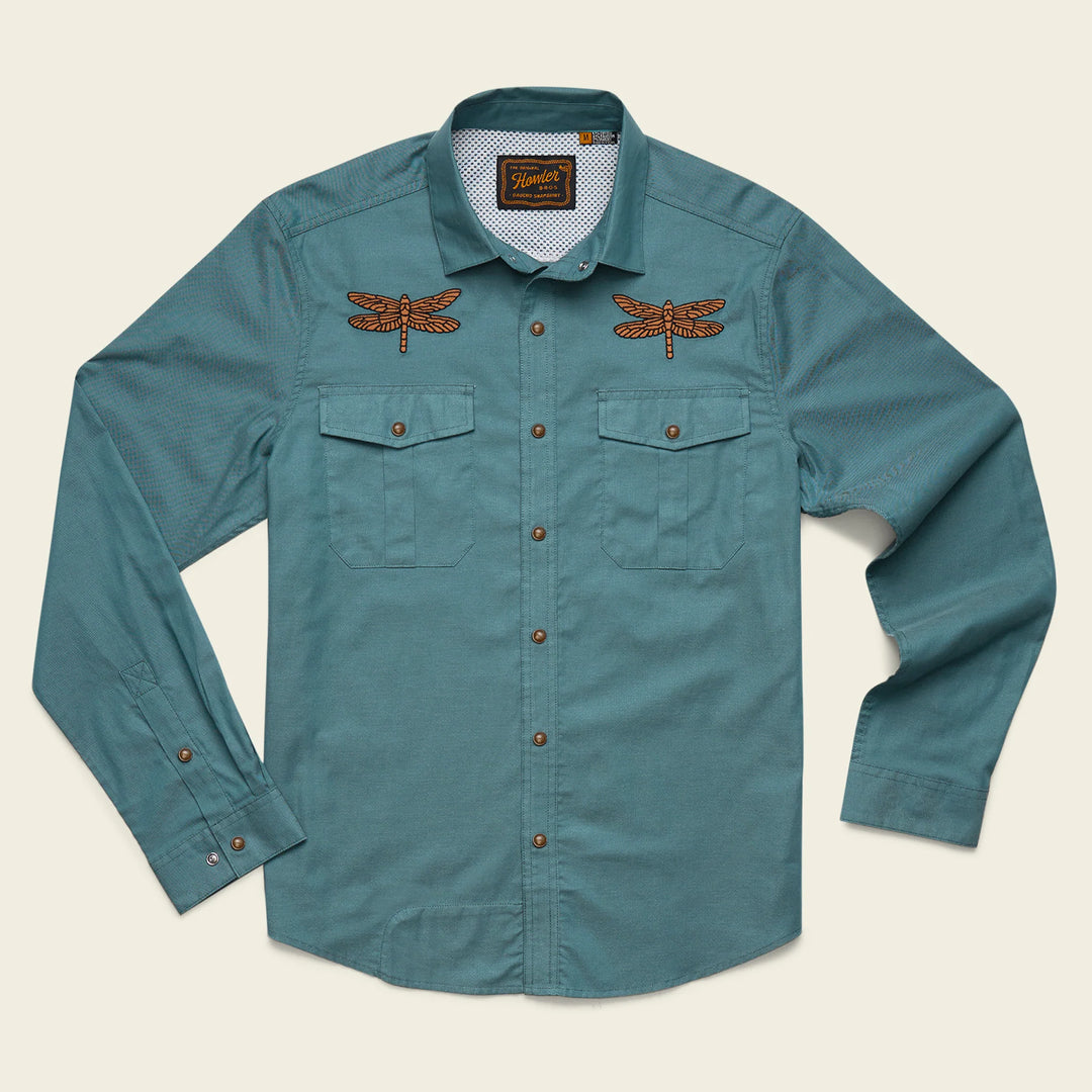 Teal shirt with dragonfly embroidery on a beige background