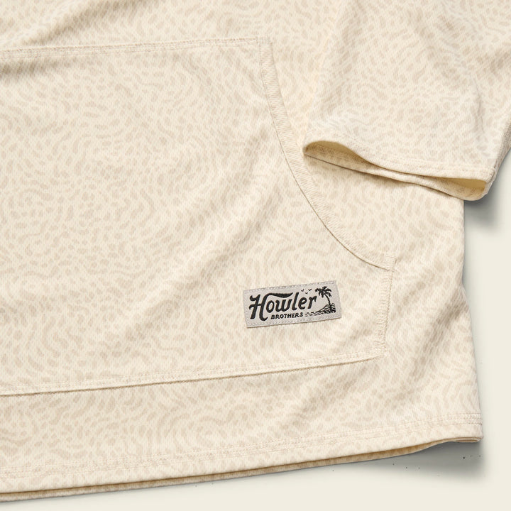 Close-up of a beige quilt with a Howler Brothers logo on a white background