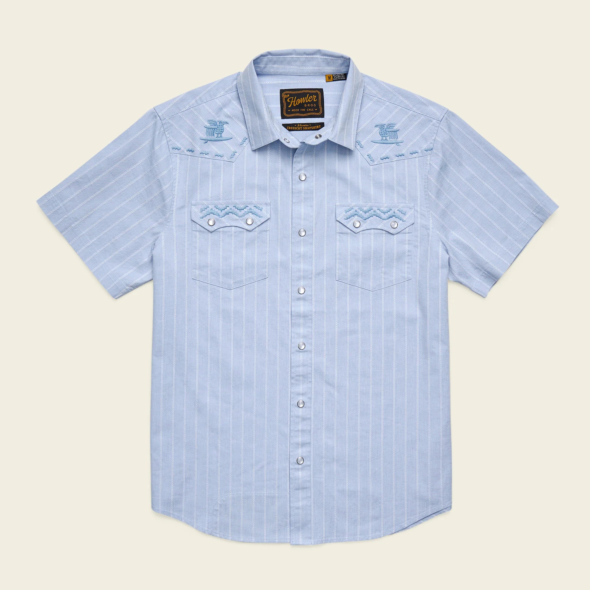 Light blue striped shirt with brand logo on a beige background