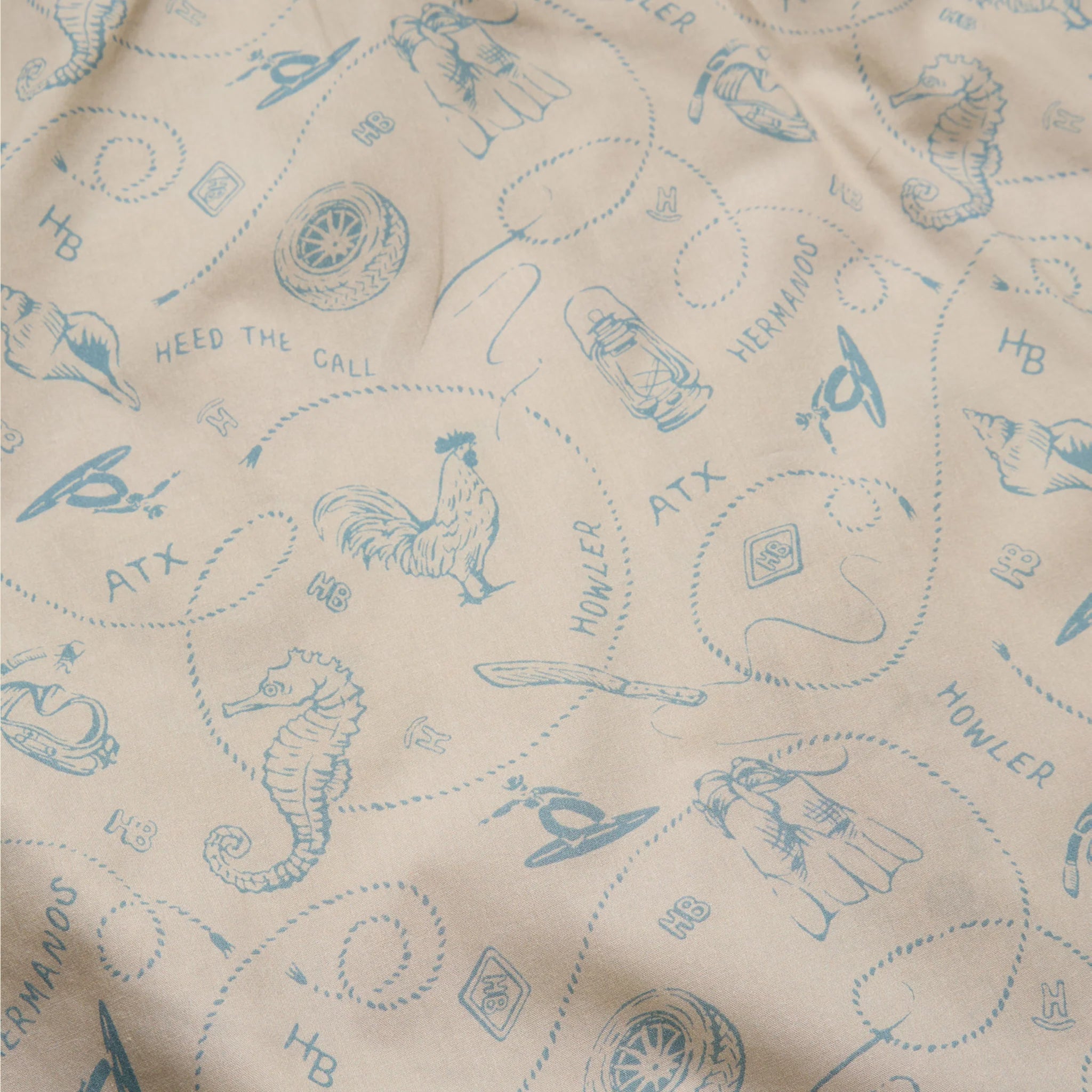 Beige fabric with blue embroidered patterns and text