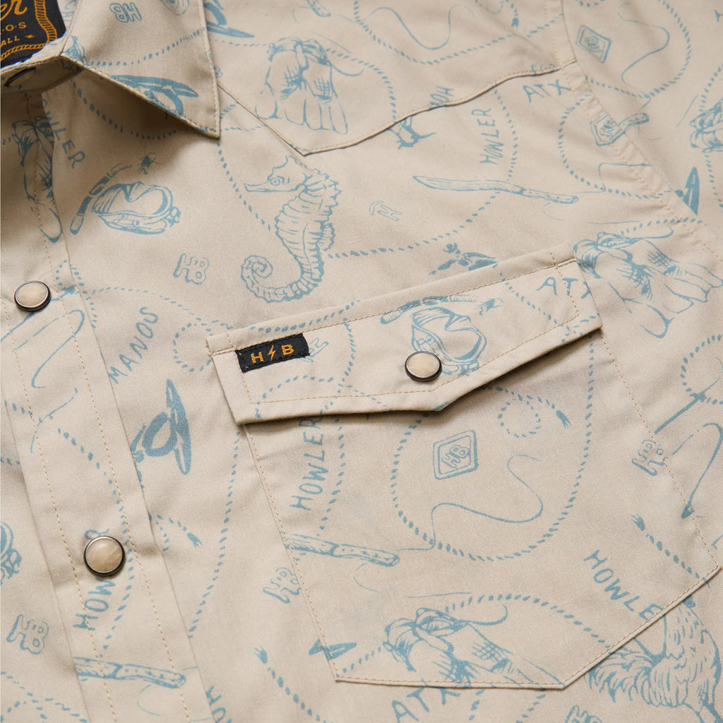 Close-up of a beige shirt with blue graphics and 'H&B' logo.