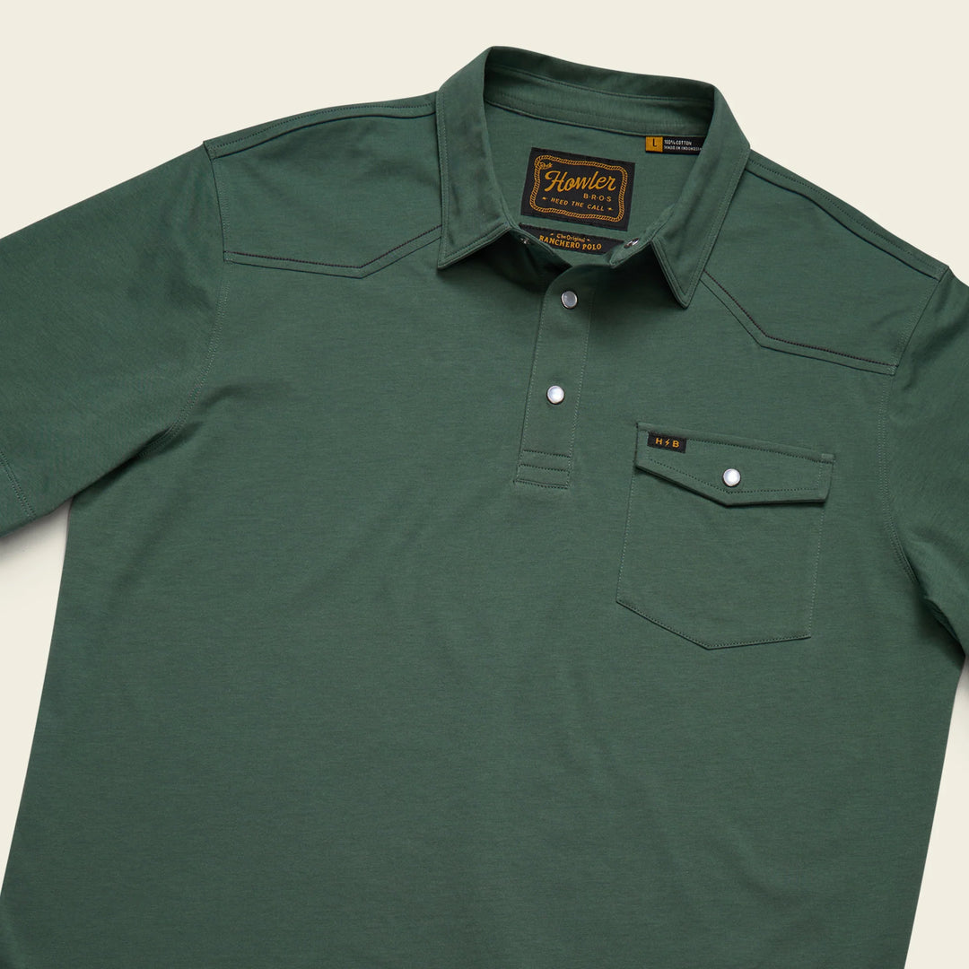 Green polo shirt with a brand label on a light beige background
