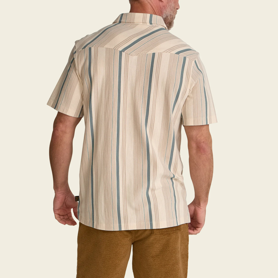 Man wearing a beige and blue striped shirt on a plain background