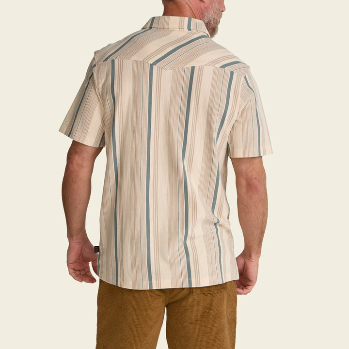 Man wearing a beige and blue striped shirt on a plain background