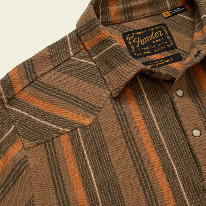 Close-up of a brown and orange striped shirt with a brand label on a light background