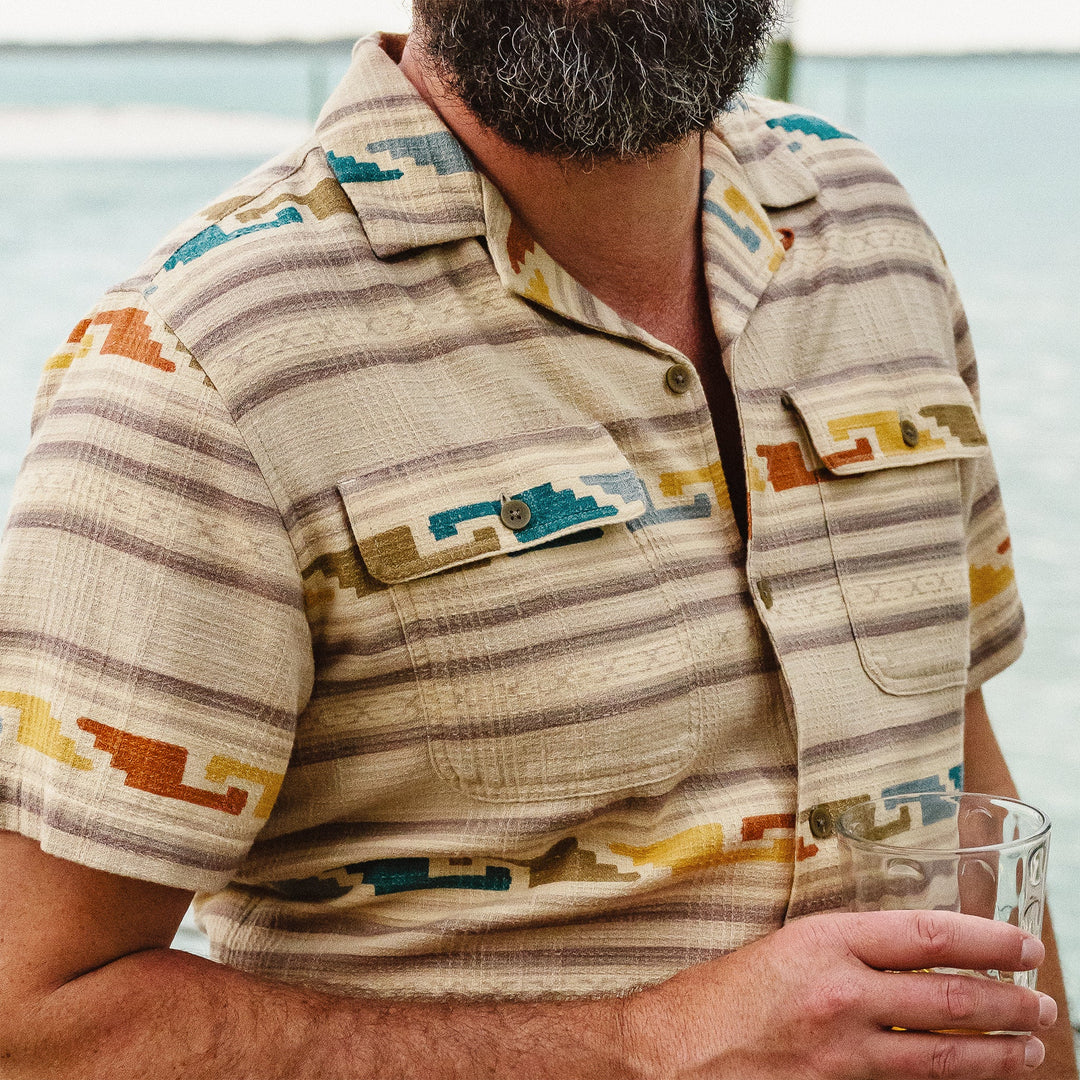 Man wearing a patterned shirt with a blurred background