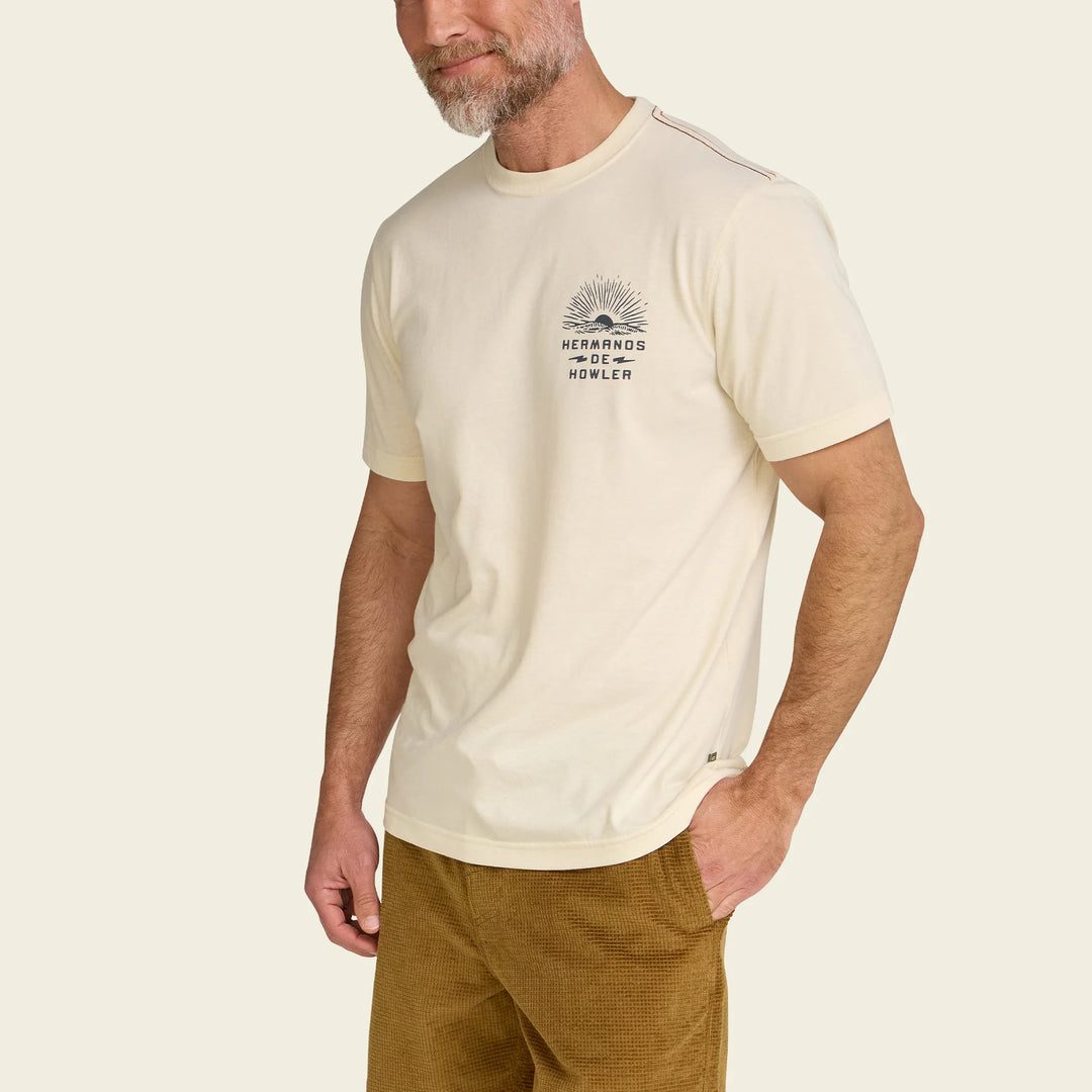 Man wearing a cream t-shirt with a logo on a beige background