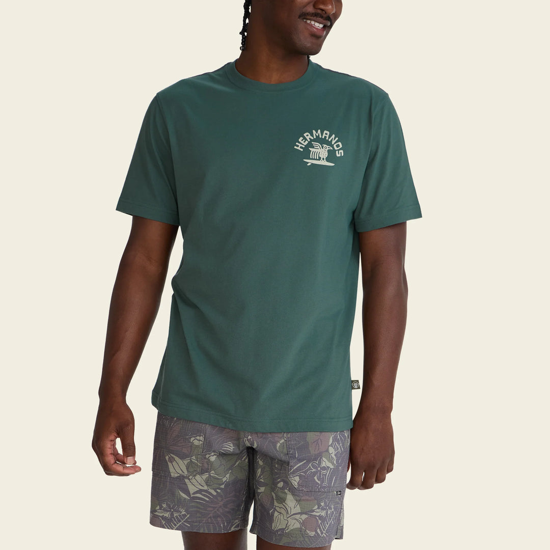 Man wearing a green t-shirt with a logo on a beige background