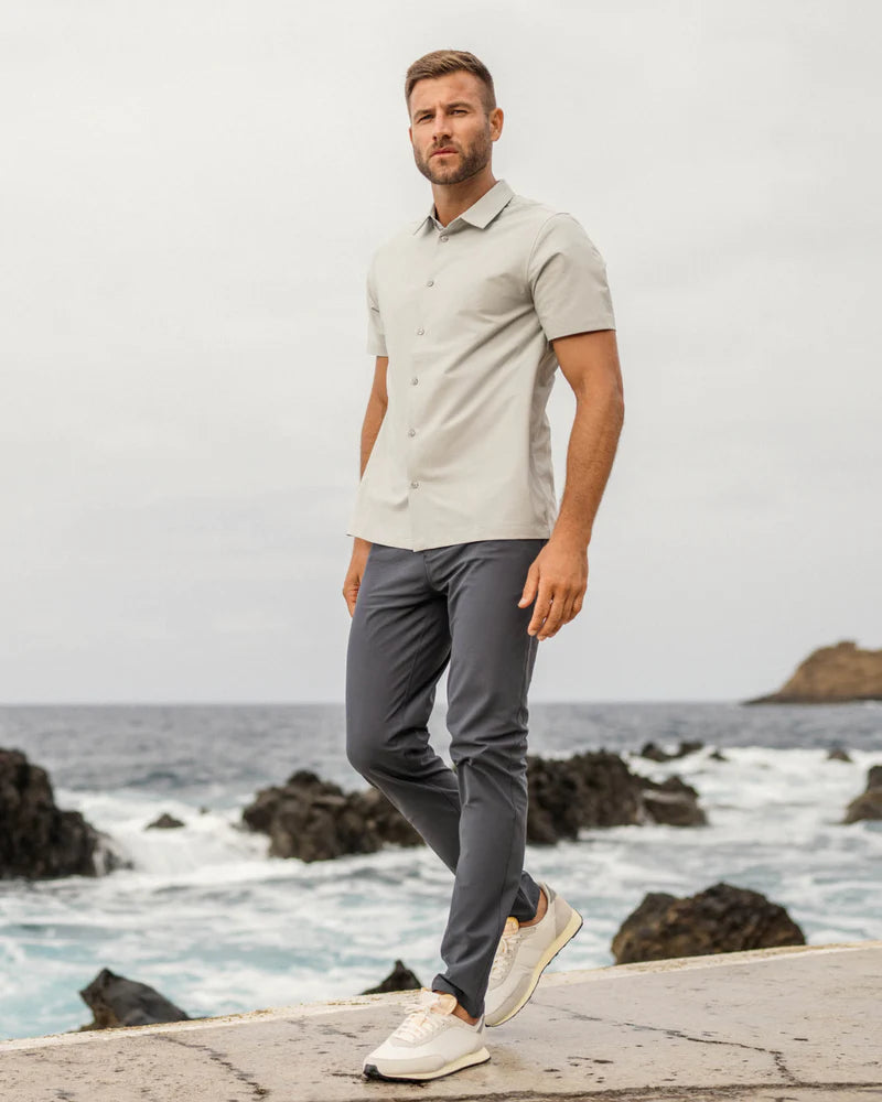 Men's meta pant in gray walking on a pier near the ocean
