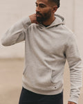 Man wearing a gray hoodie against a neutral background