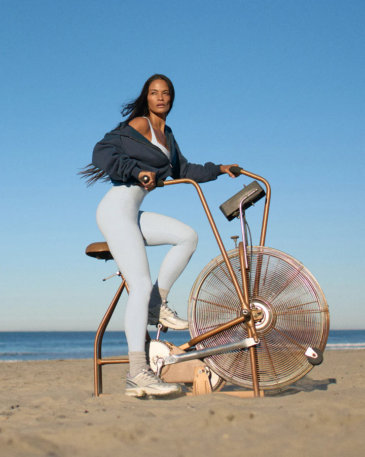 Person riding a unique bicycle with large wheels on a beach