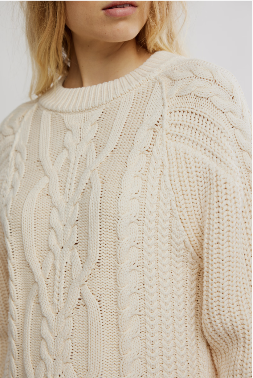 Close-up of a beige cable knit sweater