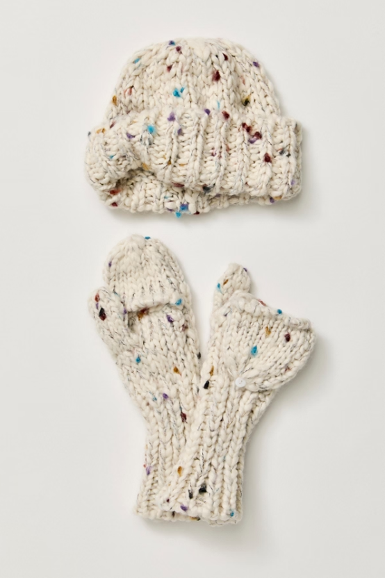 A knit winter accessory set featuring a matching beanie and fingerless mittens in an off-white cream color with multicolored flecks, laid flat on a light gray background.