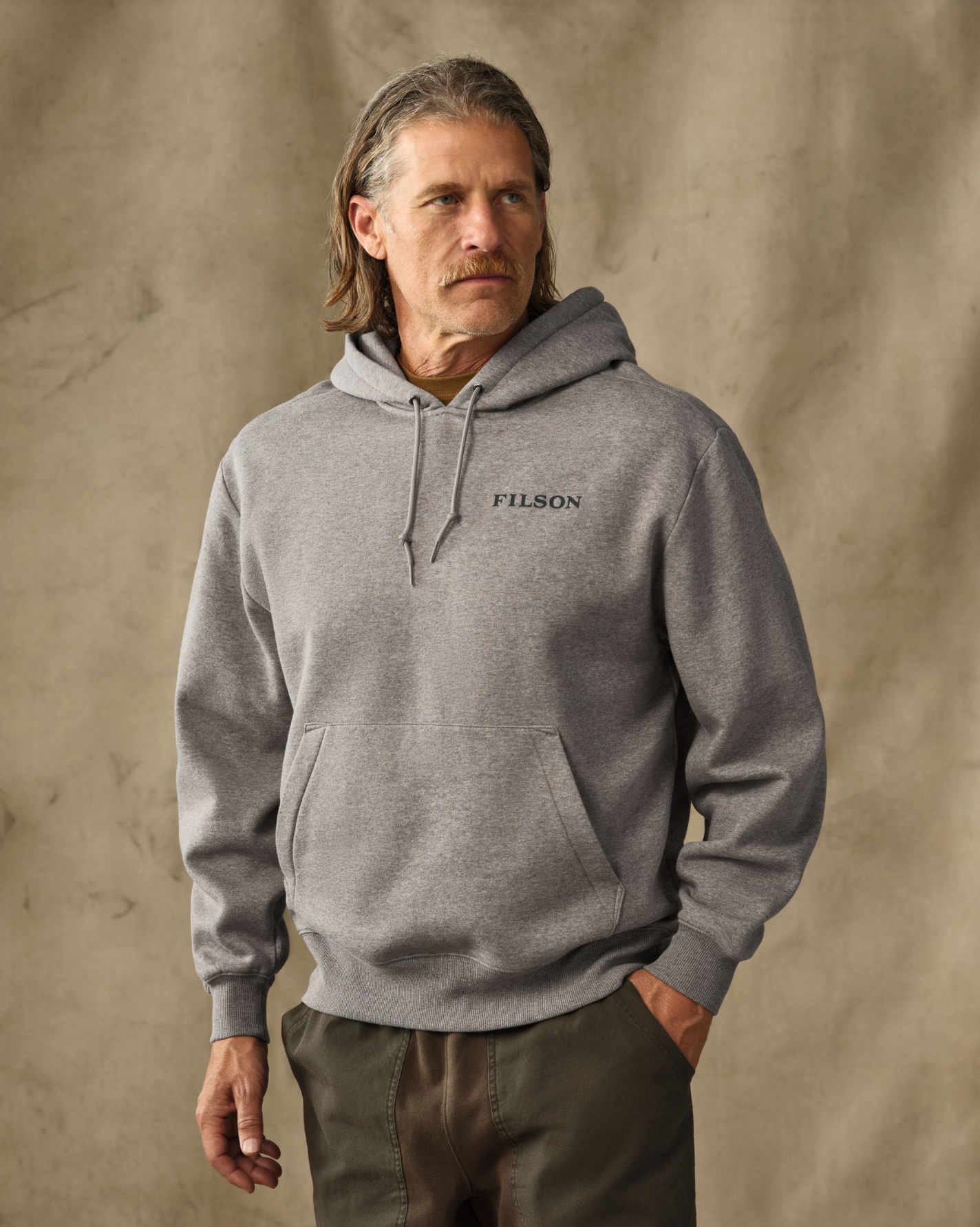 male model wearing a gray hoodie in a studio