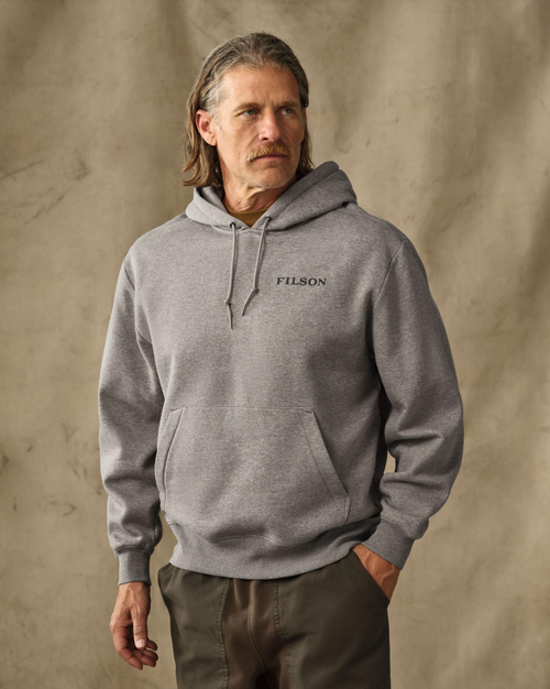 male model wearing a gray hoodie in a studio