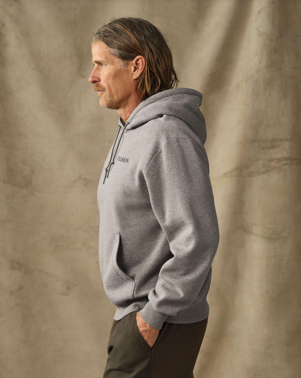 male model wearing a gray hoodie in a studio