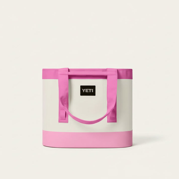 Pink and white YETI cooler bag on a black background