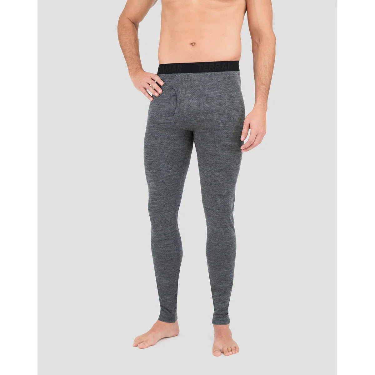 Person wearing gray thermal leggings on a plain background
