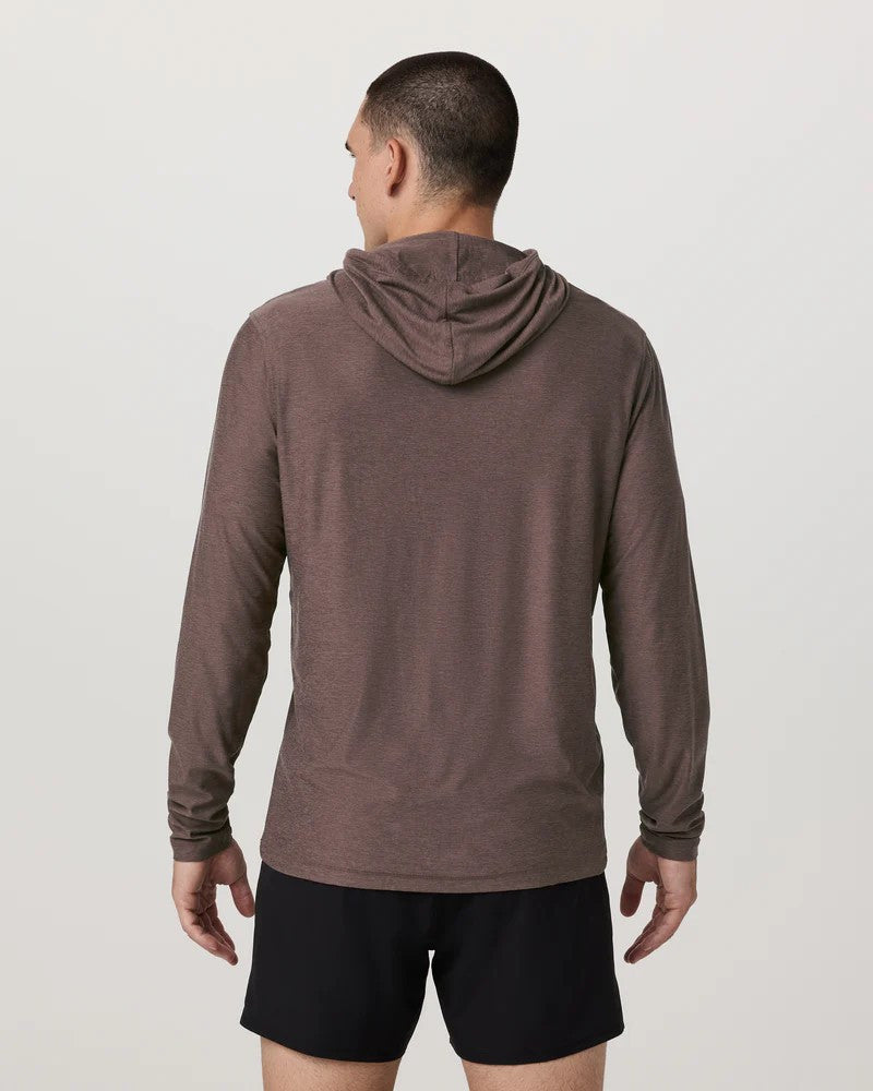 Man wearing a brown hoodie and black shorts on a light gray background